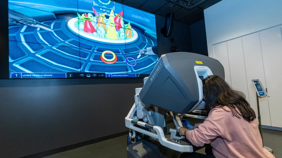 Guest uses robotic surgery simulator at Rosenfeld Hall opening event. The system is compatible with platforms used in operating rooms at Ronald Reagan UCLA Medical Center.