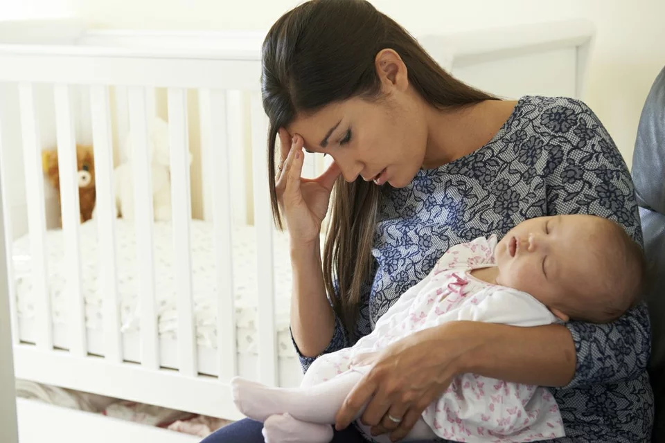 Mother struggling holding newborn baby depicting the common breastfeeding challenge of mastitis 