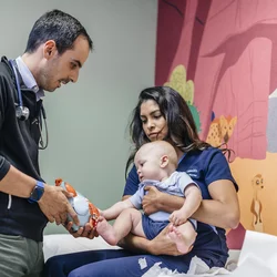 3 Challenges Pediatricians Face Doctor with Infant Patient and Mother