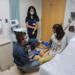 Medical students meet with a patient