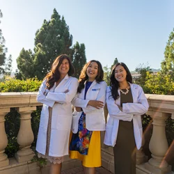 Medical student Clara Đỗ Trần Nguyễn, pictured in her white coat along with her two physician sisters, shares her story of becoming a doctor 