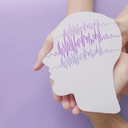 hands holding cut out of head shaped paper