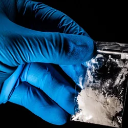 gloved hand holding medicine