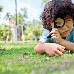 What Is Tourette Syndrome Child on Grass Looking Through Microscope